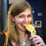 Woman smiling with a Sudsies cookie near her mouth