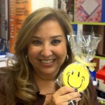 Michelle holding a smiley face cookie wrapped in cellophane